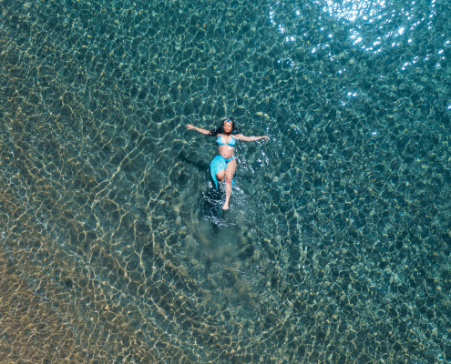 New mom floating in the ocean for a drone photo