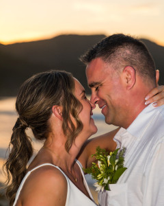 Bride and groom embracing on a pristine white-sand beach in St. Croix, at Sunset with turquoise Caribbean waters