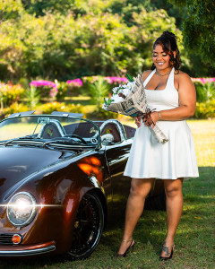 Birthday portrait of a woman with a classic Porsche and smiling at her bouquet of flowers in St Croix
