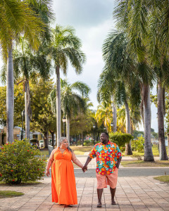Couple walking hand-in-hand between the palm trees at golden hour