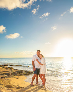 Romantic couple embracing during golden hour sunset engagement session on the beach