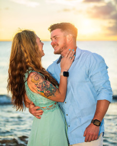 Romantic couple embracing during golden hour sunset engagement session on the beach