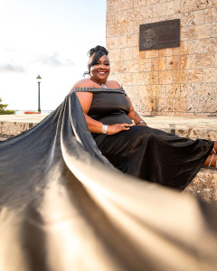 Smiling woman laughing during her outdoor birthday photoshoot with a flowing dress