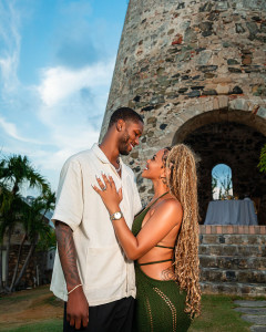 Engaged couple smiling together near a historic sugar mill during a tropical island engagement session in St Croix